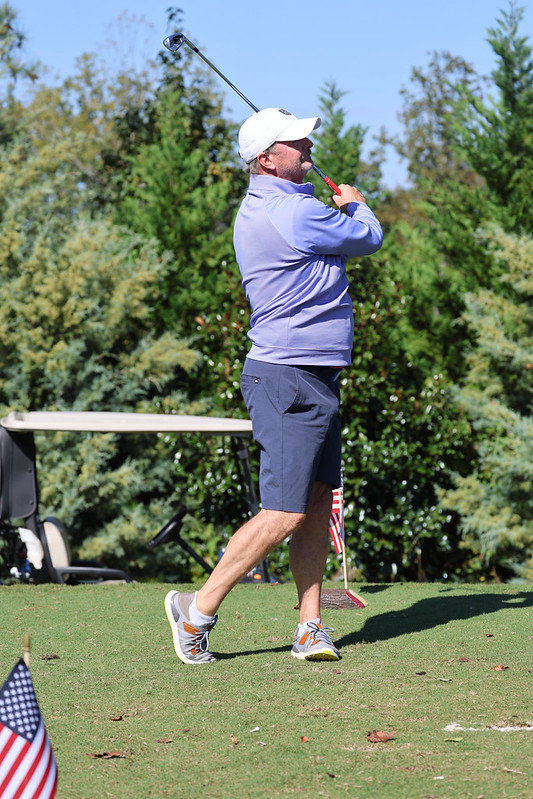 Golfer at the end of his swing, at the Georgia golf tournament to benefit veterans